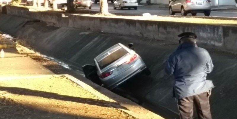 Derrapa automóvil y cae a canal en Las Quintas