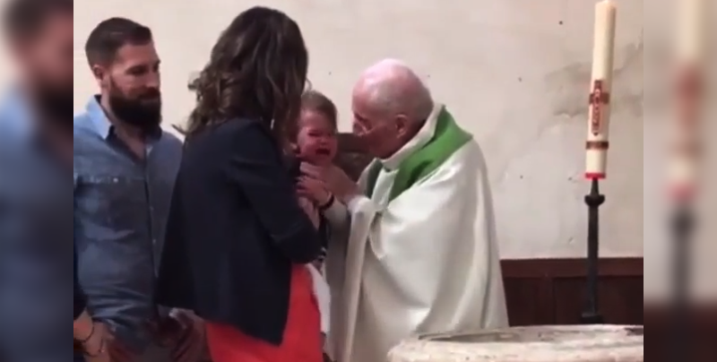 Un sacerdote golpea a un bebé