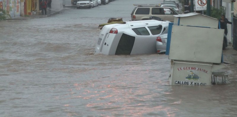 Carros volteados por la calle Francisco Villa dejaron las inundaciones