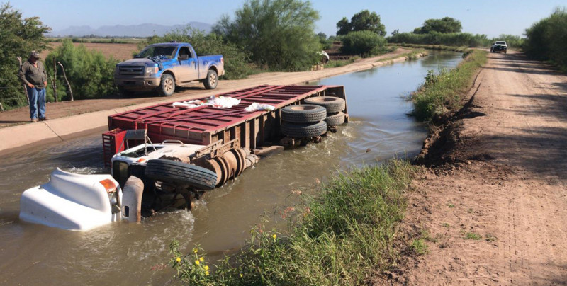 Cae tráiler cargado de fertilizante a canal