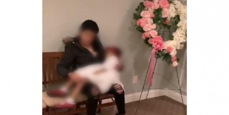 Madre arrulla por última vez el cuerpo sin vida de su hija en el funeral y conmueve a miles (video)