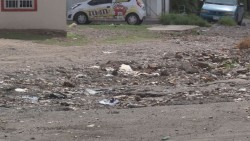 Calle en pésimo estado, llena de piedras grandes y basura