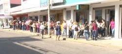 ¡Madrugan! madres de familia para canjear vales electrónicos por uniformes escolares.