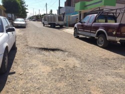 Llena de baches Calle Artículo 115