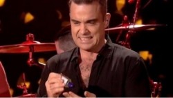 Robbie Williams se desinfecta las manos tras tocar a sus fans
