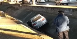 Derrapa automóvil y cae a canal en Las Quintas