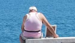 Este hombre lleva la foto de su esposa a la playa todos los días
