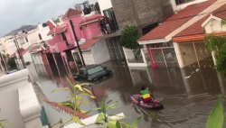 Jóvenes aprovechan lluvia e inundación para navegar en Kayak e improvisar alberca