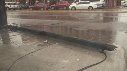 Poste de teléfono tirado en banqueta
