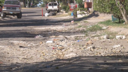 Con pavimento dañado y basura calle Municipio de Culiacán