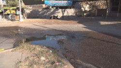 Mala combinación: fuga de aguas negras y bache